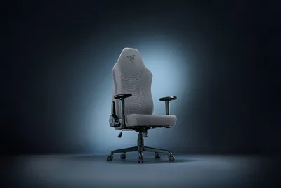 A gaming chair is shown against a dark, spotlighted background.