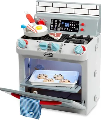 A toy kitchen stove with food items on top and inside.