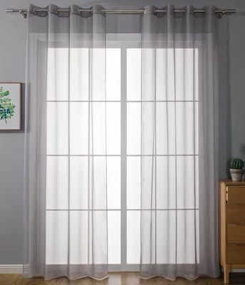 A sheer gray curtain hangs in front of a large window with a grid pattern.