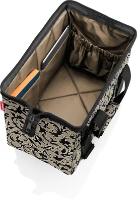 An open tote bag with a patterned exterior and tan interior, showing internal compartments and some items placed inside.
