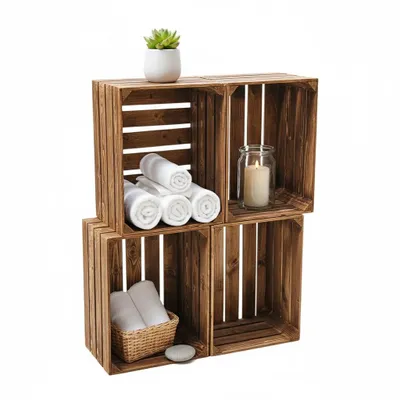 Four wooden crates stacked to form shelves, decorated with towels, a plant, and a candle.