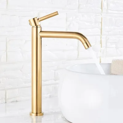 A brushed gold faucet is shown in a bathroom setting, with water flowing into a white sink.