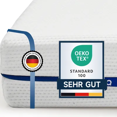 A close-up of a white mattress with blue trim, featuring certification labels.