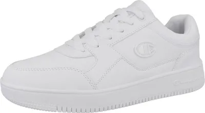 A white Champion Rebound Low sneaker is shown from a side angle against a white background.