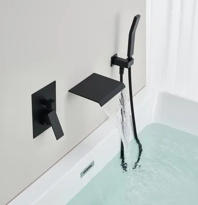 A black built-in bathtub faucet with a waterfall spout and a handheld showerhead is shown mounted on a light gray wall above a white bathtub filled with water.