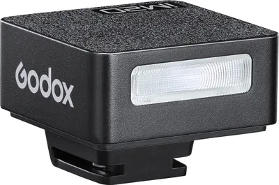 A close-up studio shot of a black Godox iM20 mini on-camera speedlite.