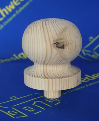 A wooden finial on a blue background with yellow text and graphics.