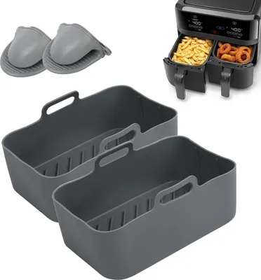 A set of gray silicone air fryer liners and two gray silicone oven mitts are displayed on a white background, with a black dual air fryer in the background containing french fries and onion rings.