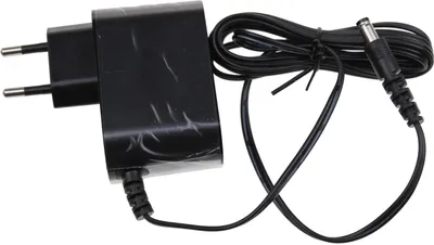 A black power adapter with a European plug and a coiled cable with a barrel connector.