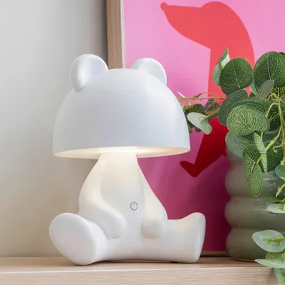 A white bear-shaped lamp sits on a shelf.