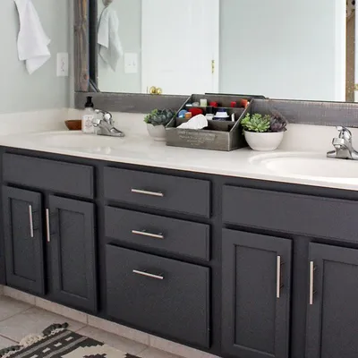 A modern bathroom vanity with dark gray cabinets and a white countertop.