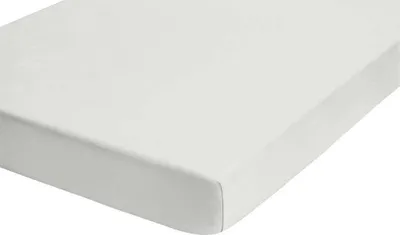 A close-up, angled view of a white fitted sheet on a mattress.