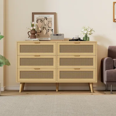 A wooden dresser with cane-woven drawer fronts sits in a living room setting.