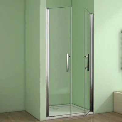A shower enclosure with glass doors and silver handles, set against a light green wall and a wooden floor.