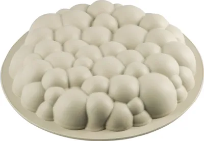 A white silicone cake mold with a bubble-like texture, placed on a white plate.