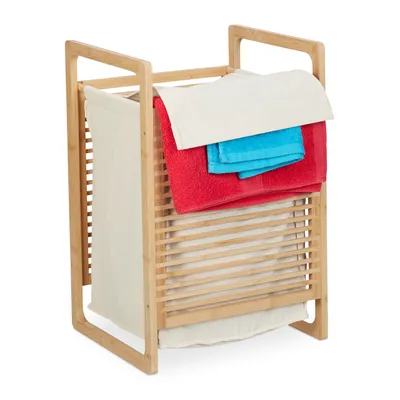 A bamboo laundry basket with a fabric liner and towels on top.