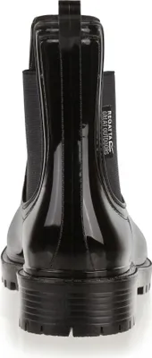The back view of a black, shiny, ankle-high rain boot with elasticated sides and a thick, lugged sole.