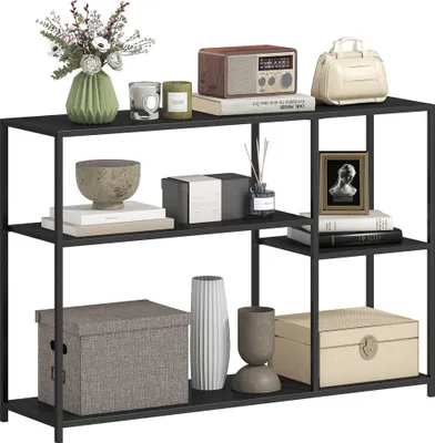 A black metal console table with four shelves, displaying various decorative items.