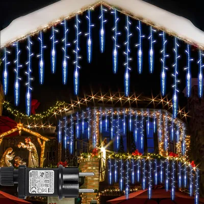 Christmas lights decorating the exterior of a house, including icicle lights on the roof and string lights on the balcony, with a nativity scene visible.