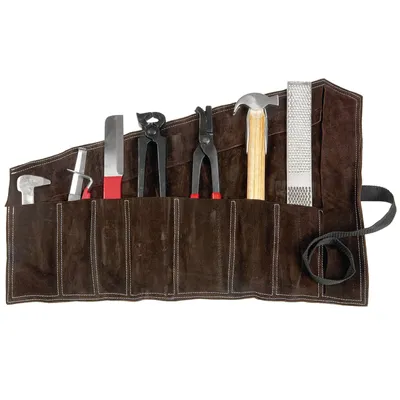 A set of farrier tools laid out in a brown leather roll-up case.