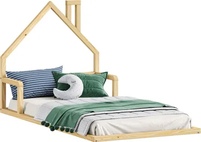A wooden children's bed with a house-shaped frame, adorned with pillows and a blanket.