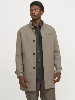 A man wearing a coat and shirt.