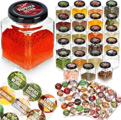 A collection of glass spice jars filled with various spices, along with sheets of spice labels.
