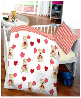 A baby crib with bedding featuring teddy bears and hearts.