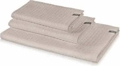 A stack of three beige waffle-weave towels.
