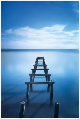 Produktbild von Wallario Premium Glasbild, freischwebende Optik, kräftige Farben, Größe 90 x 60 cm Motiv Rustikaler Holzsteg im blauen See