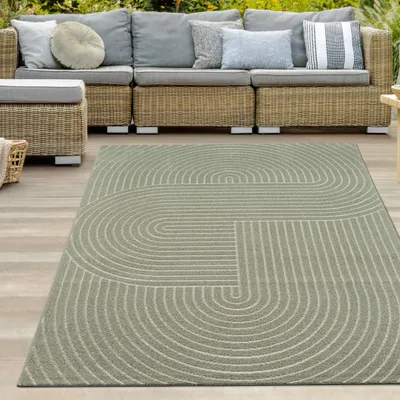 An outdoor patio with a sofa and a rug.