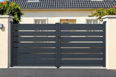 A dark gray metal gate in front of a house.