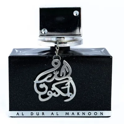 A black perfume bottle with silver Arabic calligraphy and text at the bottom, set against a white background.