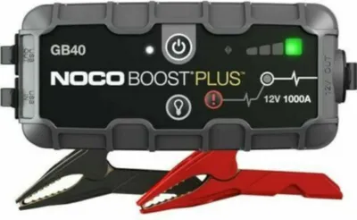 A NOCO GB40 Boost Plus jump starter with jumper cables attached.