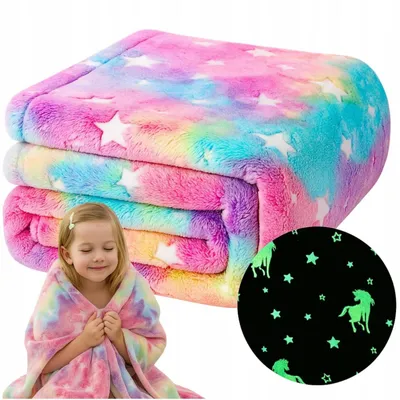 A folded blanket with a rainbow and star pattern, and a young girl wrapped in a similar blanket.