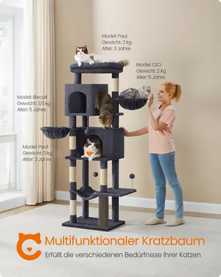 A woman is interacting with a multi-level cat tree that has several cats on it. The cat tree is in a room with a window and curtains.