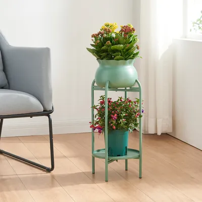 A plant stand with two potted plants next to a chair in a room.