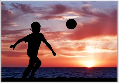 Produktbild von Wallario Wandbild Fußball - Kleiner Junge spielt im Abendrot, Größe: 70,30 x 100,30 cm, Poster mit weißem Kunststoffrahmen