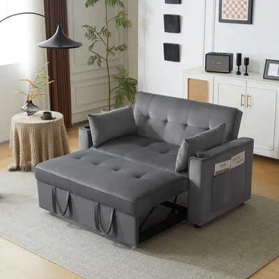 A grey sofa bed is shown in a living room setting, partially converted into a bed with an extended footrest.