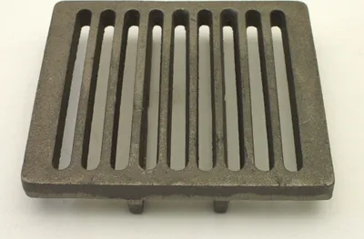 A cast iron grate for a stove or fireplace, shown from a slightly elevated angle on a white background.
