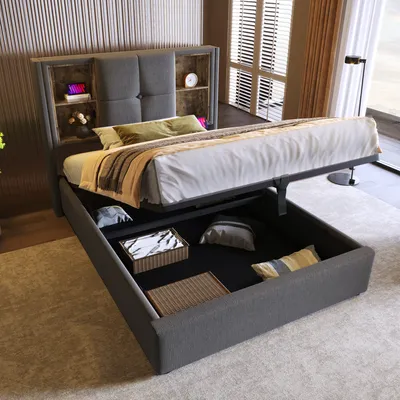 A grey upholstered bed with a headboard featuring storage shelves, shown with the storage compartment open to reveal stored items.