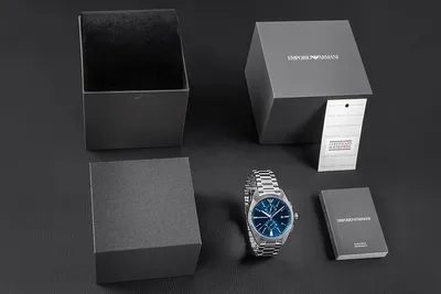 A watch and its packaging are laid out on a dark surface.