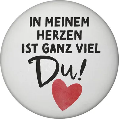 A round magnet with text and a heart graphic.