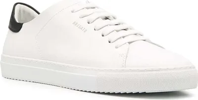 A close-up view of a white leather sneaker with a black heel accent.