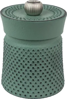 A green cast iron pepper mill with a silver top.