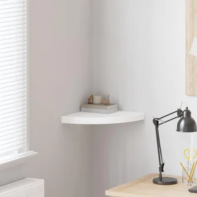 A white corner shelf mounted on a wall, with a few decorative items on it.