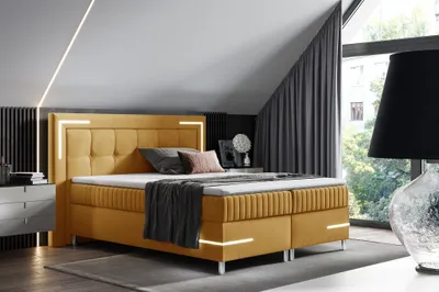 A modern bedroom with a yellow boxspring bed, featuring integrated LED lighting.