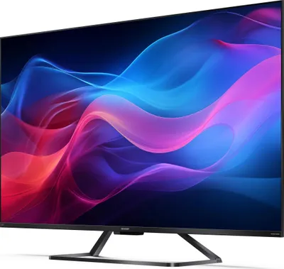 A side view of a black flat-screen television with a colorful abstract image displayed on its screen, resting on a black stand.