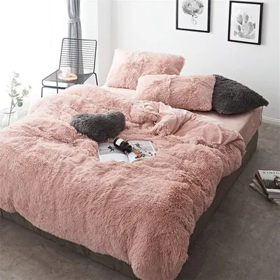 A cozy bedroom scene with a plush pink duvet and pillows on a bed.