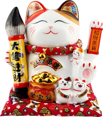 A decorative ceramic cat figurine, known as a Maneki-neko or lucky cat, is displayed against a white background. The cat is white with calico markings and is holding a brush in one paw and a waving hand in the other. It is adorned with a red and gold patte